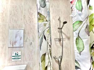 a bathroom with a shower with leaves on the wall at Hostal Cristina in Chipiona +82 photos