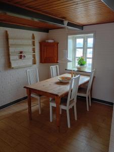 a dining room with a wooden table and chairs at Vesterhavet in Nørre Vorupør