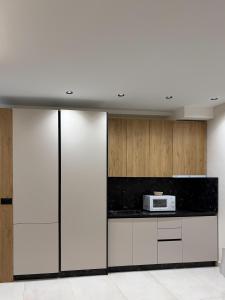 a kitchen with white cabinets and a microwave at Casa Tirana in Tirana