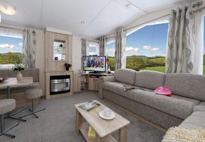 a living room with a couch and a tv at Roselands caravan park, Nr Lands End, Cornwall in St. Just