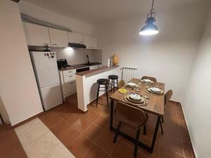 a kitchen with a table and chairs and a refrigerator at Condominio Villa Helios in Cuasso Al Monte