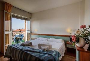 a bedroom with a bed with towels and a window at Hotel Kennedy in Lido di Savio +134 photos