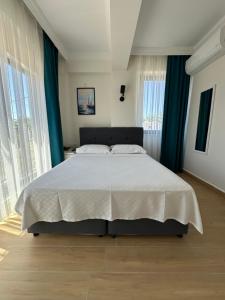a bedroom with a large bed with blue curtains at Sevgi Hotel in Ezine