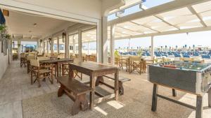 a restaurant with tables and a pool table with a boardgame at Hotel Kennedy in Lido di Savio