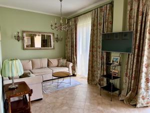 a living room with a couch and a flat screen tv at GH Mountain & Bay View with POOL in Gornji Orahovac