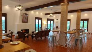 a living room with tables and chairs and a fireplace at Hacienda Los Manchones in Doña Mencía