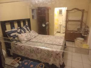a bedroom with a bed and a bathroom with a mirror at Sleep Well in Amanzimtoti