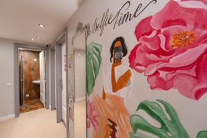 a bathroom with a pink flower mural on the wall at Yes Lisbon Hostel in Lisbon