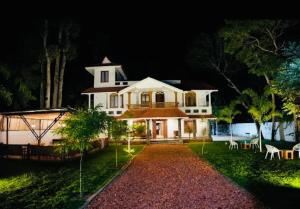 a large white house at night with a pathway at Casa de Victoria in Alleppey