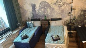 a bedroom with two beds and a wall mural at Grubhof Treetops in Sankt Martin bei Lofer +37 photos