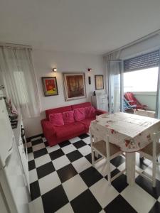 a living room with a red couch and a table at FronteMare in Lido di Pomposa
