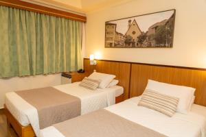a hotel room with two beds and a window at Hotel Bella Italia in Foz do Iguaçu +116 photos