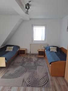 a attic bedroom with two beds and a rug at Camelia's Unterkunft in Sulzthal