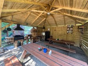 a wooden cabin with a picnic table and a stove at Penzion Alpský Dům in Železná Ruda