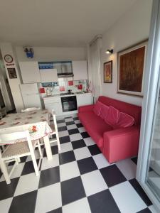 a living room with a red couch and a checkered floor at FronteMare in Lido di Pomposa +15 photos