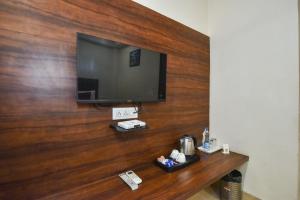 a flat screen tv on a wooden wall at Pineberry Hotels - Near Golden Temple in Amritsar +85 photos