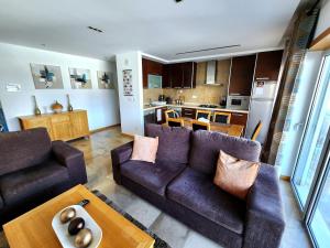 a living room with two couches and a kitchen at Shell Bay Retreat in São Martinho do Porto