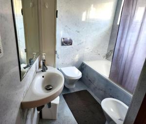 a bathroom with a sink and a toilet and a shower at Shell Bay Retreat in São Martinho do Porto +4 photos