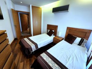 a hotel room with two beds and a mirror at Shell Bay Retreat in São Martinho do Porto