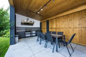 a patio with a table and chairs and a kitchen at Cozy HillSide in Borşa