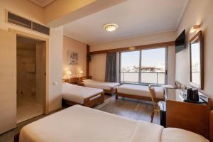 a hotel room with two beds and a window at Xenophon Hotel in Athens +88 photos