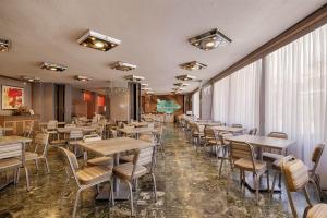 a restaurant with tables and chairs in a room at Xenophon Hotel in Athens