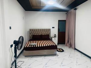 a bedroom with a bed in the middle of a room at Misty Garden in Maskeliya