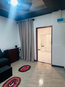 a living room with rugs on the floor and a sliding door at Misty Garden in Maskeliya