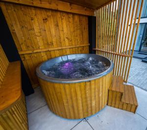 a large wooden tub with a bench in front of it at Cozy HillSide in Borşa