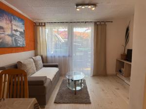 a living room with a couch and a glass table at Zupan apartments in Ližnjan