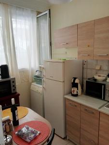 a small kitchen with a refrigerator and a table at Stydio Damos in Kavála