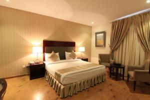 um quarto de hotel com uma cama e duas cadeiras em Aliah Towlan Palace em Riyadh