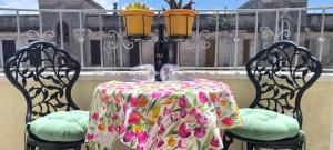 a table and chairs with a tablecloth on a balcony at Domu e Cannonau in Nuoro