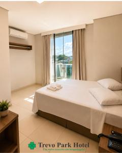 a bedroom with a bed and a large window at Trevo Park Hotel in Nova Alvorada do Sul