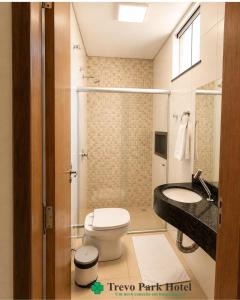 a bathroom with a toilet and a sink at Trevo Park Hotel in Nova Alvorada do Sul