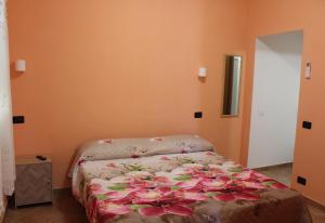 a bedroom with a bed with pink flowers on it at Agriturismo I TRE TIGLI in Rignano Flaminio
