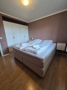 a bedroom with a large bed with white sheets at Apartment on Leknes with a view in Vestvågøya