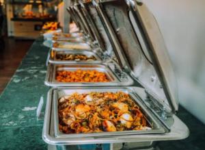 a row of trays of food on a counter at Hotel mong'are in Narok