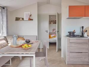 a kitchen with a table with a bowl of fruit on it at CAMPING PLEIN SOLEIL in Lourdes