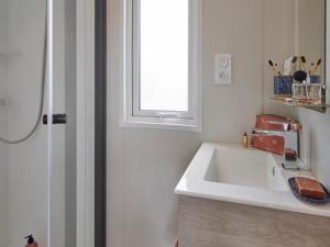a kitchen with a white sink and a window at CAMPING PLEIN SOLEIL in Lourdes