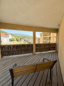 a wooden bench sitting on a deck with a view at Maison classée 3 étoiles avec garage et 2 terrasses in Arles-sur-Tech