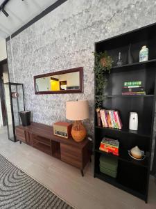 a living room with a table and a mirror at The Teduh Homestay By Rumah Mimpi in Kertih