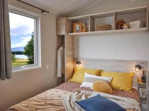 a bed in a small room with a window at CAMPING PLEIN SOLEIL in Lourdes