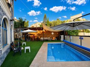 a backyard with a swimming pool and an umbrella at סוויטה בכפר ירכא in Yarka +24 photos