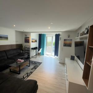 a living room with a couch and a table at Stilvolle Wohnung im Erdgeschoss in Kolbermoor