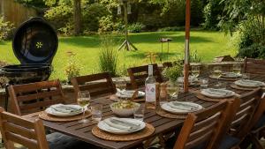 a wooden table with plates and wine glasses on it at Glasfryn in Wolford
