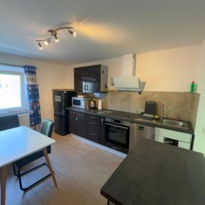 a kitchen with black appliances and a table in it at Stilvolle Wohnung im Erdgeschoss in Kolbermoor