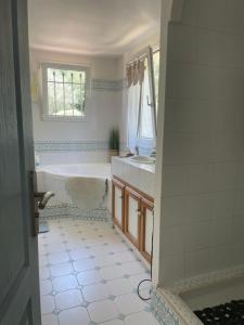 a bathroom with a tub and a sink at Mas Elaia in La Farlède
