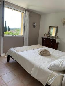 a bedroom with a large bed and a window at Mas Elaia in La Farlède