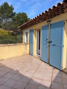 a garage with blue doors on a house at Mas Elaia in La Farlède